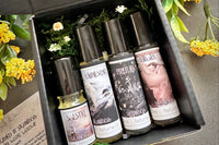 Muse Fragrances by SugarMuses® nestled in a small black box packed with organic moss and other botanicals.
