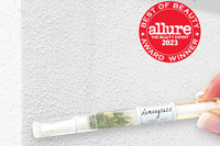 Lemongrass cuticle oil pen with Allure Best of Seal against a white concrete background by Greenmade goods.