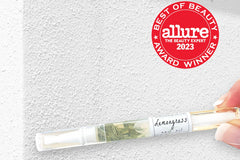 Lemongrass cuticle oil pen with Allure Best of Seal against a white concrete background by Greenmade goods.