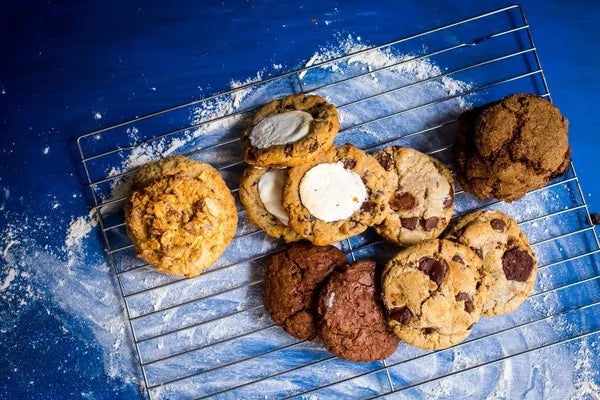An assortment of fresh baked cookies on a cooling rack