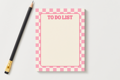 To Do List notepad with a pink and cream checkered border and an open writing space, next to a black pencil