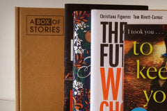Brown box filled with fiction books, showcasing a variety of gripping titles and intriguing covers, perfect for mystery lovers.