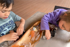 child working with crystals, focused on selecting them, engaging in organization and exploration with crystals