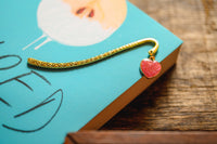 Introverts Retreat box closeup of a corner of a novel with a gold bookmark with a sparkling heart charm.