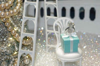 tiffany inspired diamond ring in a blue gift box with Christmas decor in tiffany branded colors surrounding the gift