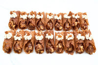 Apple Pie Brandy Snaps DIY baking kit result with 28 filled lace desserts arranged in four neat rows on a white tray.