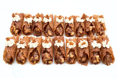 Apple Pie Brandy Snaps DIY baking kit result with 28 filled lace desserts arranged in four neat rows on a white tray.