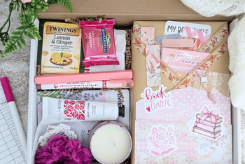 surprise book box with new book, annotation supplies, relaxation and self care items packaged neatly in a box