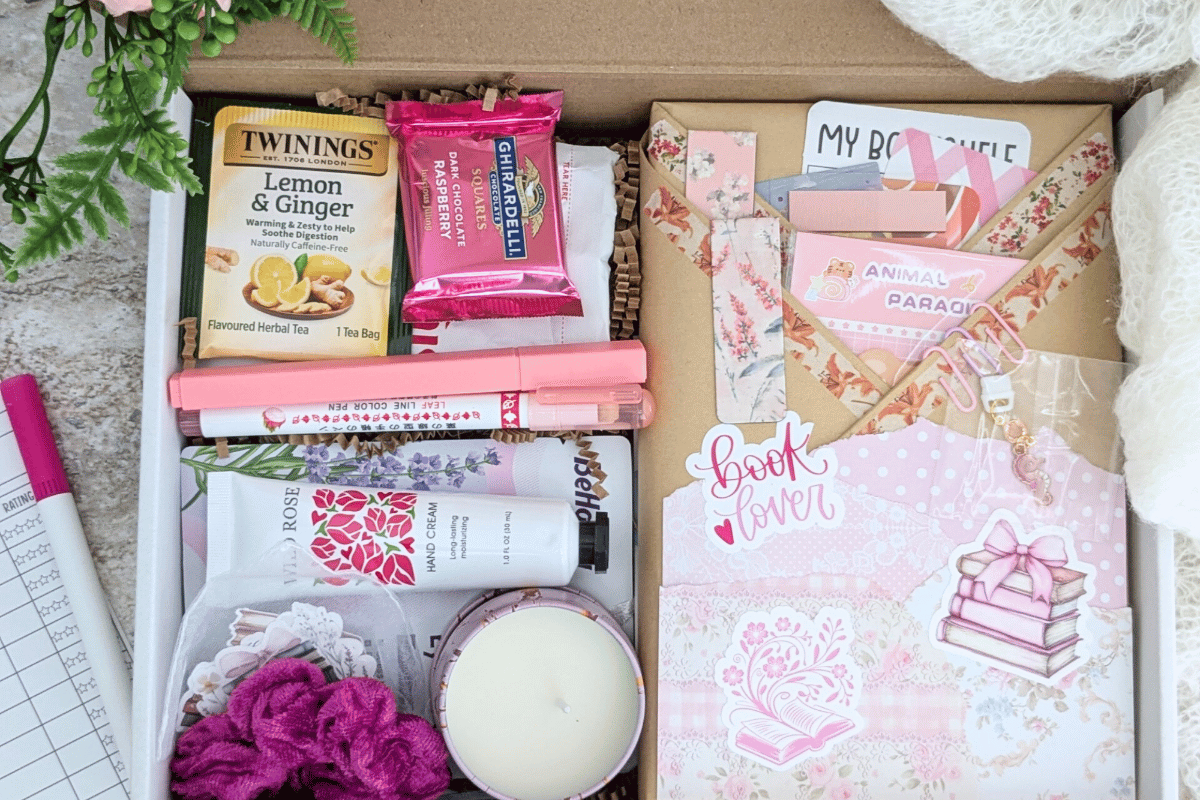 surprise book box with new book, annotation supplies, relaxation and self care items packaged neatly in a box