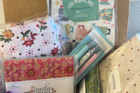 Each box is filled with high quality cotton fabric, a pattern and notions to complete the projects.  There is extra in each box.