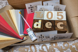Perpetual Calendar Blocks Box contents include paper strips, wooden blocks, cardstock cutouts, paintbrush and sealer.