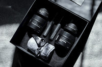 Photo of black skin care and spa products primarily for men. Packed in black gift set box and with a towel in it.