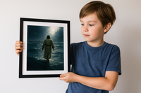Young boy holding an 8x10 art print of Jesus walking on the stormy sea toward the disciples’ boat, in a black frame.