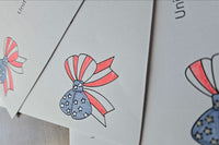 Close-up of red, white and blue patriotic bow designs with stars and stripes printed on white envelopes.