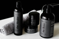Close up photo of mens spa and self care products from the brand Man Myth with all black colors and a towel included.