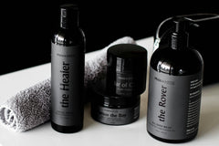 Close up photo of mens spa and self care products from the brand Man Myth with all black colors and a towel included.