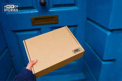 Brown subscription box filled with four young adult light reading books, featuring engaging stories and relatable characters for teen reader