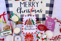 A festive Believer's Box VP subscription box with a "Merry Christmas" sign, ornaments, and candles celebrating faith