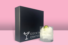 A Cocktail subscription box displaying a gin and tonic cocktail in front of a gift box from Cocktail Crates