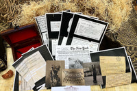Vintage documents, vintage photographs and a newspaper article rest on top of papyrus and woodwool and vintage scarf and box
