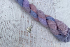 A mini Skein of Hand Dyed Merino Sock Weight Yarn and a coordinating stitch marker. Suitable for knitting and crocheting 
