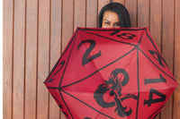Lady hiding playfully behind a open Dungeons and Dragons print umbrella. The umbrella is shaped like a D20 dice.