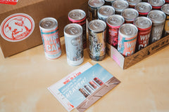 A bunch of cans with the label Wine in a Can and a card that says Welcome to Wine in a can heaven.