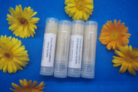 4 Natural, homemade lip balms  Raspberry, Watermelon, Pink Bubblegum and Cherry flavours. Surrounded by calendula flowers 