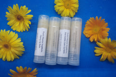 4 Natural, homemade lip balms  Raspberry, Watermelon, Pink Bubblegum and Cherry flavours. Surrounded by calendula flowers 