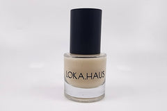 Creamy-colored bottle of LOKA.HAUS's 'Radiant Serum'. Unlock natural brilliance. A beauty elixir for radiant skin.
