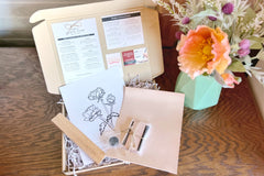 This is a Crate Club box open and on display. This box contains a leather rectangle, magnetic wood frame, floral pattern, etc.