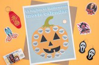 A hallowen-themed subscription box. Items include horror stickers, VHS enamel pin, scream earrings, movie scratch print with pumpkin. 