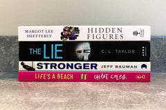 Brown subscription box filled with four light reading books, featuring charming stories and uplifting themes for easygoing book lovers.