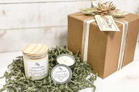 Hands holding a jar candle made of soy with the scent of Egyptian Amber from the Rustic Barn subscription box.