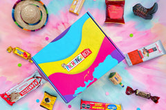 Pachanga Box with tie dye background with some Latin American snacks and toys for aesthetic reasons. Toys not included. 