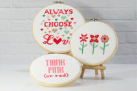 Always choose love cross stitch.  Featuring words Think Pink (and red).  One design has 3 cross stitch flowers with simple green stems