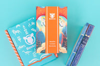 Two children reading books from Bookroo's Tween Book Club subscription on a colorful rug with additional books nearby