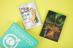 Two children reading books from Bookroo's Tween Book Club subscription on a colorful rug with additional books nearby