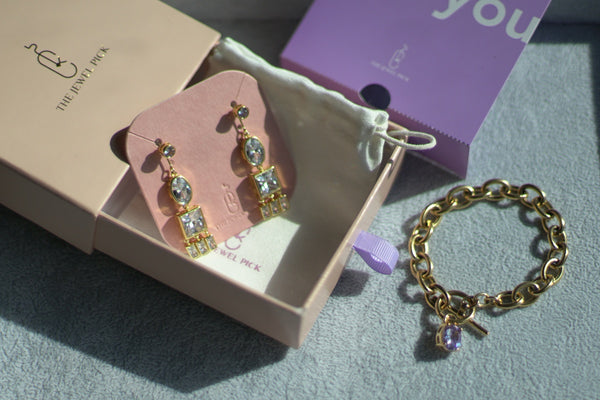 A gold bracelet and earrings presented in The Jewel Pick box, courtesy of thejewelpick brand.
