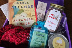 A sampling of what a box may look like - book, bookmark, handknit coasters, teabag, candle, and hot cocoa!!