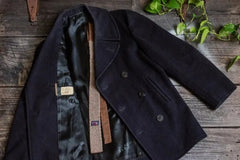 A Navy-issue wool pea coat satin lining, corduroy pockets, and original stenciling. Paired with 60s knit tie. 