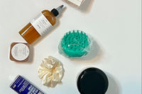 flat lay spread of products included in Her Crown and Glory’s Subscription box against a white background 