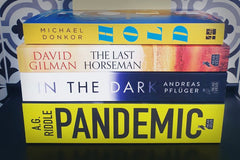 Brown subscription box filled with four surprise fiction books, offering captivating stories and diverse plots for literature lovers.