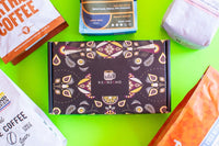 This photo contains several coffee bags along with packaging for the Keanjaho coffee subscription shipment.