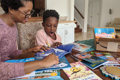 Three colorful children's books from the Kids Read Daily Book Club: "My Family and Me," "The Thrifty Guide to Ancient Rome," and "Freddie Mole, Lion Tamer"