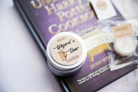 image of travel-sized candle in tin. The candle is closed and the label name of "Wizard's Beer" is visible. 