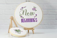 inspirational words, new beginnings on modern cross stitch design in purple embroidery thread with bonus designs including purple flowers
