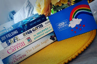 Brown subscription box filled with four light reading books, featuring charming stories and uplifting themes for easygoing book lovers.