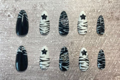 Set: Zebra'd. Black and white alternating zebra inspired set. Zebra french tip on thumbs. Black star gems on index/ring. Zebra hearts on mid
