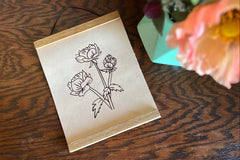 A finished Crate Club Project - the leather rectangle with floral pattern burned onto it, the magnetic frame hangs from a string